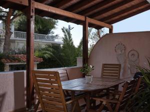a wooden table and chairs on a patio at Evi's Voula Home in Athens
