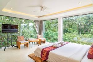 a bedroom with a bed and a large window at Villa Tiwera 6br Private Pool & Sea View in Chaweng Noi Beach