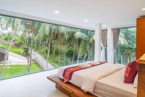 a bedroom with a large glass window with a bed at Villa Tiwera 6br Private Pool & Sea View in Chaweng Noi Beach +23 photos