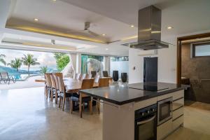 a kitchen and dining room with a table and chairs at Villa Tiwera 6br Private Pool & Sea View in Chaweng Noi Beach