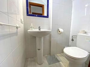 a white bathroom with a sink and a toilet at Huerta Enmedio 15 Terraced house in tranquil location in Conil center sleeps 4 in Conil de la Frontera +10 photos
