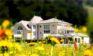 a large white house in a field of flowers at Grütter Luxury Apartments in Ischgl