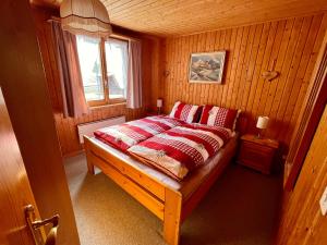 a bedroom with a bed with red sheets and a window at Chalet in Vals in Vals