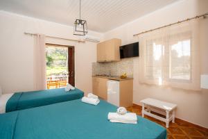 a room with two beds and a kitchen at Eros appartments in Kalamitsi