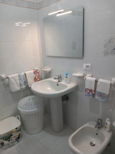 a bathroom with a sink and a toilet and a mirror at Appartamento L'Orchidea in Forio d'Ischia +50 photos