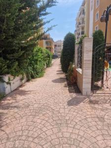 una pasarela de ladrillo en una ciudad con árboles y edificios en Aparthotel Salena, en Sunny Beach