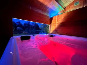 wanna z hydromasażem z czerwonym barwnikiem w pokoju w obiekcie Cottage Le Rosie au bord du lac avec jacuzzi w mieście Prouilly