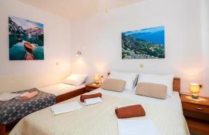 two beds in a small room with two lamps and two beds at Apartment Complex in Lokva Rogoznica in Lokva Rogoznica