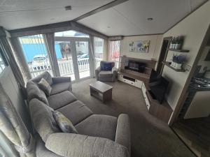 a living room with a couch and a television at Modern caravan Robin Hood Rhyl in Rhyl