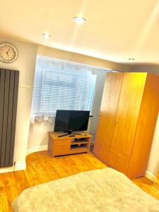 Un dormitorio con una cama y un televisor y una ventana. en Vf apartments kingsbury, en The Hyde