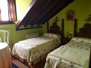 2 camas en una habitación con paredes verdes en Posada La Casona De Ucieda, en Ucieda de Arriba