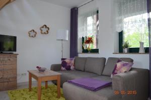 a living room with a couch and a table at Spreewaldscheune am Fließ-Ferienwohnungen am Wasser in Burg in Burg