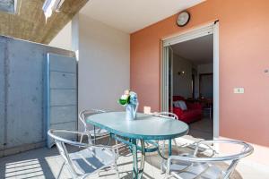 a table with chairs and a vase of flowers on it at Appartamento Sisto - MyHo Casa in San Salvo