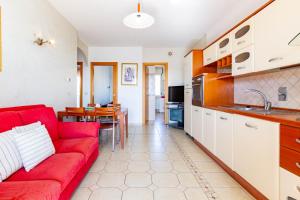 a living room with a red couch and a kitchen at Appartamento Sisto - MyHo Casa in San Salvo +11 photos