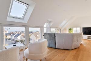 a living room with white furniture and large windows at Villa Calypso - Vue mer à Saint-Lunaire in Saint-Lunaire