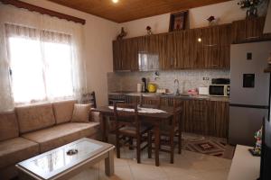 a kitchen and living room with a couch and a table at Villa Selenica Zhitom in Poliçan