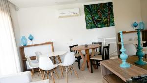 a dining room with white chairs and a table at Casa e Flat Rio e Praia in Paulista