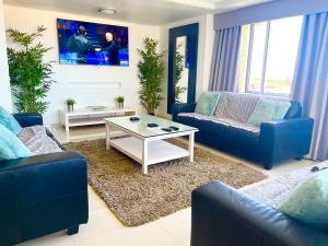 ein Wohnzimmer mit zwei blauen Sofas und einem Tisch in der Unterkunft Villa Las Vistas Costa Adeje in Callao Salvaje