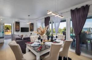 ein Esszimmer und ein Wohnzimmer mit Tisch und Stühlen in der Unterkunft Private Resort Lumianni- 2 Houses in Kaštela