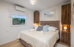 ein Schlafzimmer mit einem großen weißen Bett und einem Fenster in der Unterkunft Private Resort Lumianni- 2 Houses in Kaštela + 57 Fotos