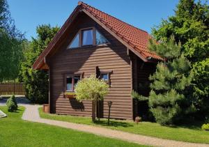 a log cabin with a tree in front of it at Domki na Mazurach - Rybical 65 in Ryn