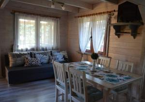 a living room with a table and a couch at Domki na Mazurach - Rybical 65 in Ryn +21 photos