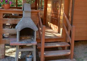 an outdoor oven on the porch of a cabin at Domki na Mazurach - Rybical 65 in Ryn