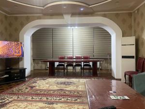 a dining room with a table and chairs and a television at Cozy apartment 2 in Samarkand