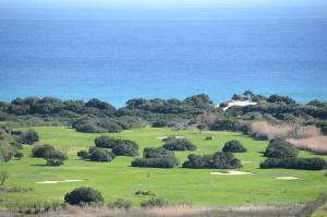 a golf course with the ocean in the background at Hotel Spartivento in Chia