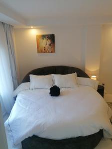 a black cat sitting on top of a white bed at Luxury marsa beach in La Marsa