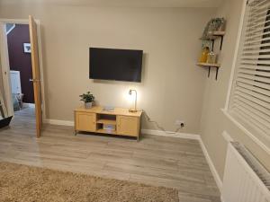 a living room with a television on a wall at No 14 Langley Work and Stay 3BR House Ideal for Contractors in Wick