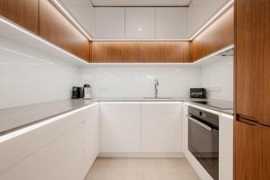 Una cocina con gabinetes blancos y un fregadero. en inQse Plus Wroclaw Marina, en Wroclaw