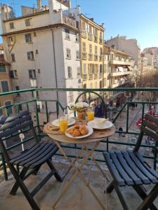a table with food and drinks on a balcony at Toulon Soleil Et Douceur ll in Toulon