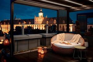 Un balcón con una silla y una mesa y un edificio en inQse Plus Wroclaw Marina, en Wroclaw