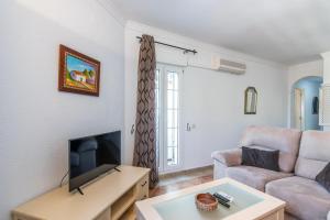 a living room with a couch and a tv at Las Dunas - Playa Punta del Moral PLHD141P160 in Punta del moral