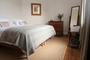 a bedroom with a bed and a dresser and a mirror at Elmhurst in Ovingham