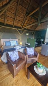 a bedroom with a bed and a couch and a table at Harmony Luxury Tents & Safari in Addo
