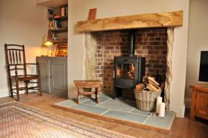 a brick fireplace with a stove in a living room at Elmhurst in Ovingham