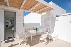 a white dining room with a white table and chairs at Deluxe Maisonette With Private Jacuzzi in Glifades