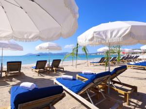 a beach with chairs and umbrellas and the ocean at Croisette Beach Hotel Cannes - MGallery Collection in Cannes