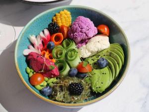 a bowl filled with vegetables and fruits on a table at Croisette Beach Hotel Cannes - MGallery Collection in Cannes