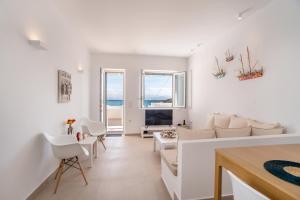 a living room with white furniture and a view of the ocean at Deluxe Maisonette With Private Jacuzzi in Glifades