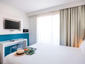 a hotel room with a bed with a hat on it at Ibis Styles Menton Centre in Menton