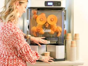 a woman standing in front of a coffee machine at Ibis Styles Menton Centre in Menton