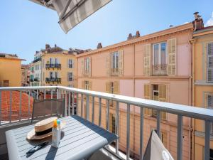 a table on a balcony with a view of buildings at Ibis Styles Menton Centre in Menton