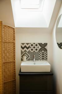 a bathroom with a sink and a skylight at La Borgnardais - chambres étape tout équipées in Loutehel