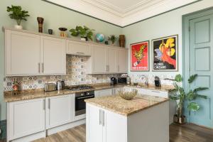 a kitchen with white cabinets and marble counter tops at Judges Lodgings Boutique Hotel Apartments in Gloucester