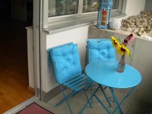 a blue table and two chairs and a vase with a flower at Studio Mythen in Schwyz