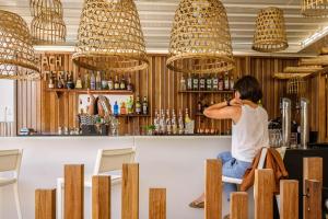 a woman sitting at a bar in a restaurant at Residence de Tourisme Ajaccio Amirauté in Ajaccio