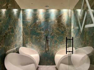 a bathroom with two urinals and two sinks at Wellness Residence Panorama - check-in at Olympia Hotel in Arabba +32 photos